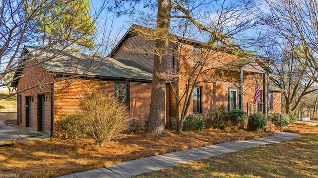 view of property exterior featuring driveway and brick siding