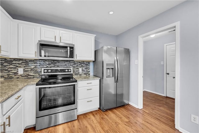 kitchen with backsplash, appliances with stainless steel finishes, and white cabinetry