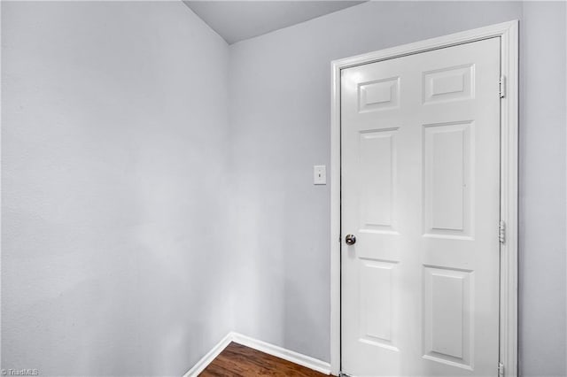 unfurnished room featuring dark wood-type flooring and baseboards