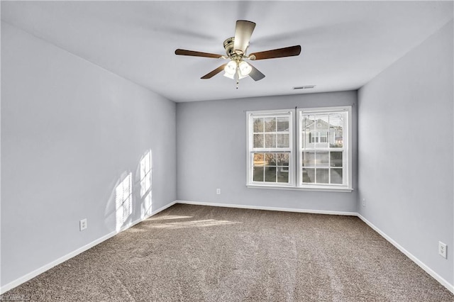 empty room featuring carpet flooring, visible vents, a ceiling fan, and baseboards