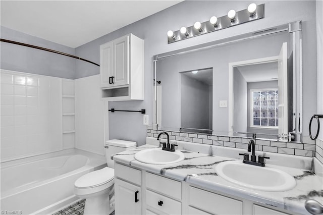 bathroom with double vanity, toilet, shower / bathtub combination, and a sink