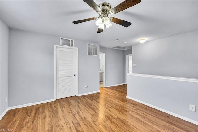 spare room with visible vents, ceiling fan, baseboards, and wood finished floors