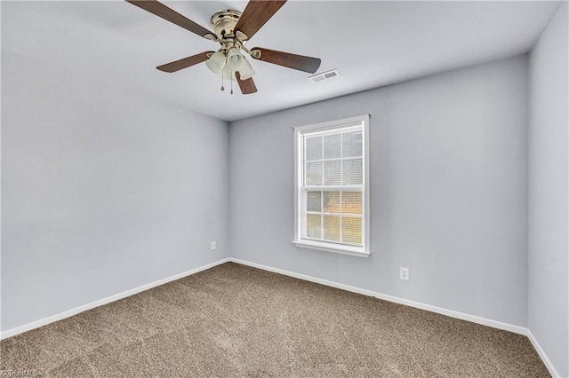 empty room with visible vents, carpet flooring, baseboards, and ceiling fan