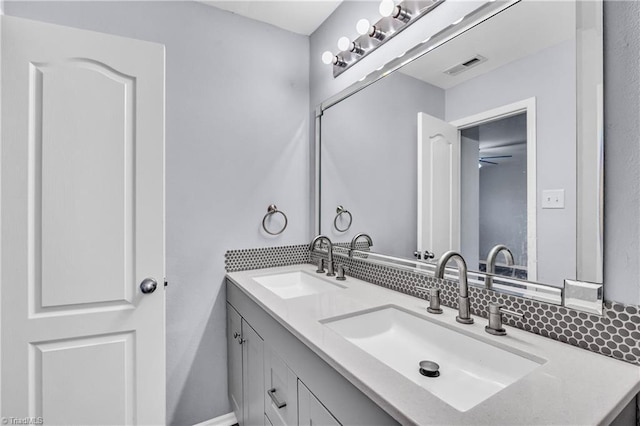 bathroom with double vanity, visible vents, and a sink