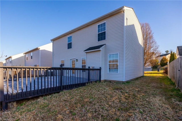 back of house featuring a deck and a lawn