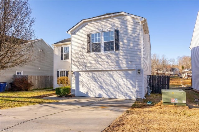 view of front of home with an attached garage, fence, and driveway