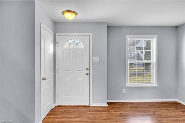 entryway with baseboards and wood finished floors