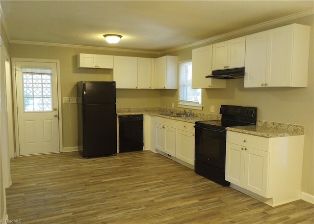 kitchen featuring light wood-type flooring, plenty of natural light, white cabinetry, and black appliances