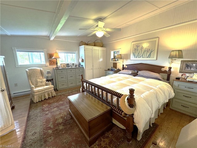 bedroom with lofted ceiling with beams, baseboard heating, wood finished floors, and a ceiling fan