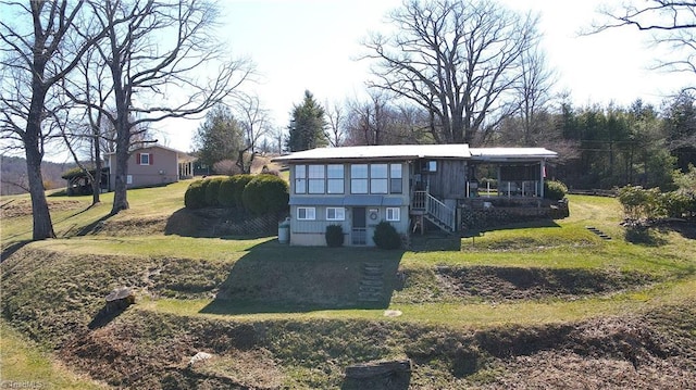 view of front of home with stairs and a front yard
