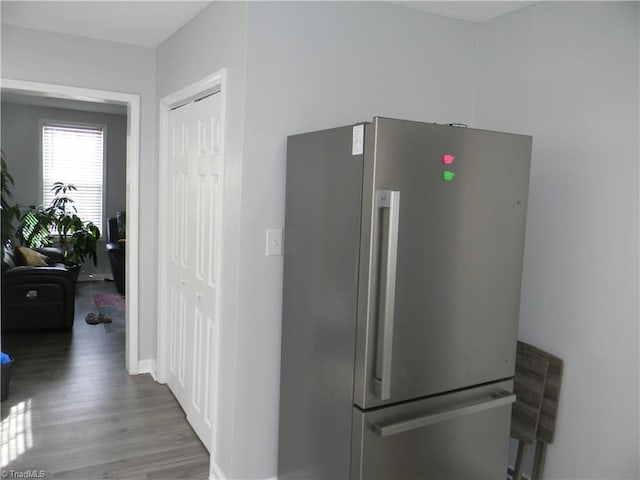 interior space with dark hardwood / wood-style floors and stainless steel fridge