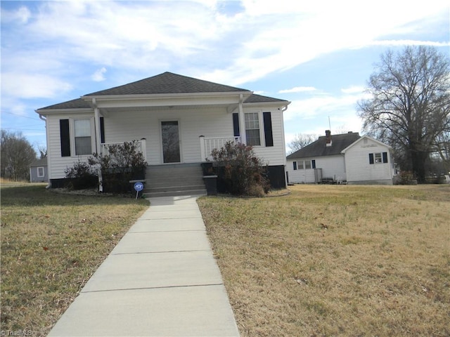 view of front of house with a front yard and covered porch