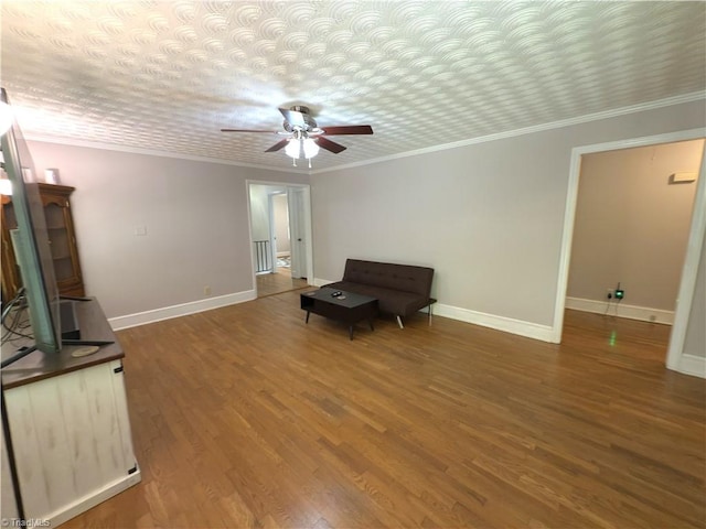 unfurnished room featuring baseboards, ornamental molding, a ceiling fan, and wood finished floors