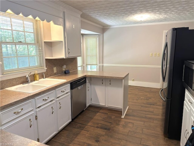 kitchen with a sink, ornamental molding, stainless steel dishwasher, and a wealth of natural light