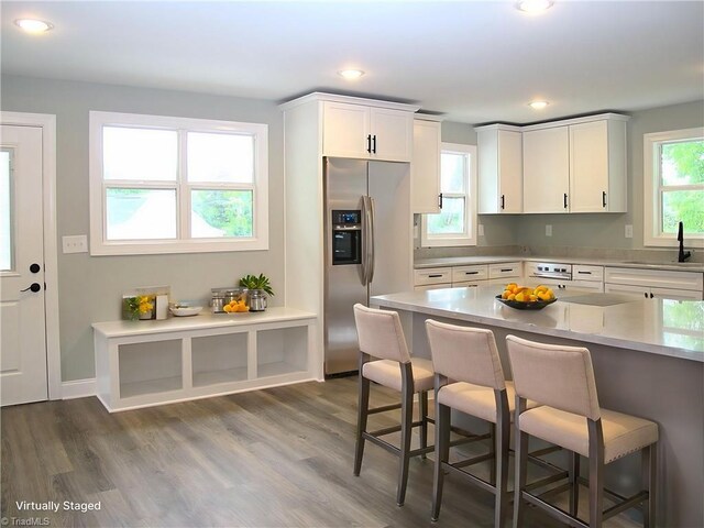 812 Midway School Rd, Winston-Salem, NC 27107 - kitchen featuring stainless steel refrigerator with ice dispenser, a sink, a breakfast bar, dark wood finished floors, and light countertops