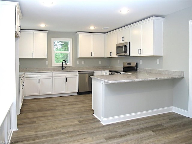 812 Midway School Rd, Winston-Salem, NC 27107 - kitchen featuring stainless steel appliances, a peninsula, a sink, light wood finished floors, and white cabinetry