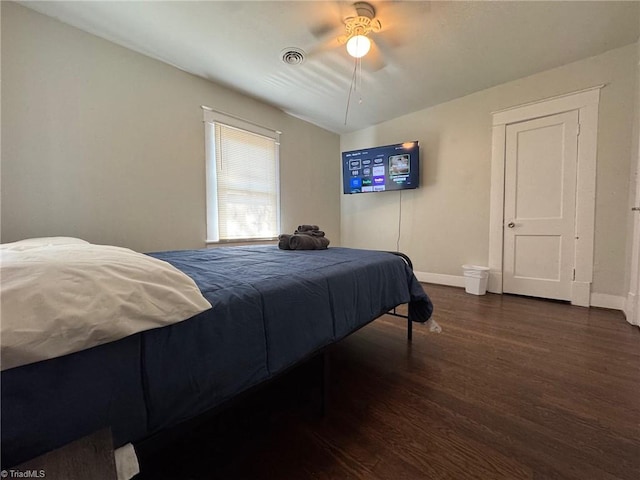 bedroom with dark hardwood / wood-style flooring and ceiling fan