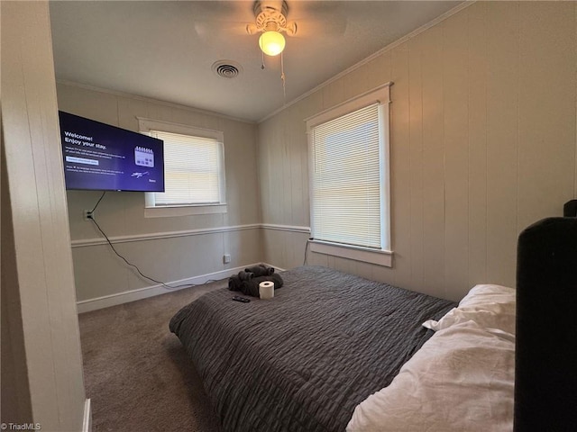 bedroom with dark colored carpet, ceiling fan, and crown molding