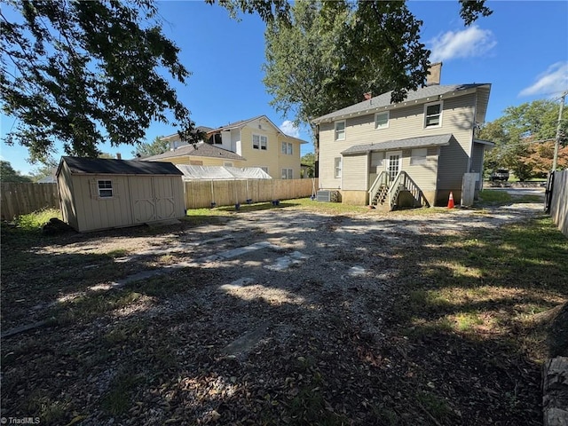 back of house featuring a shed