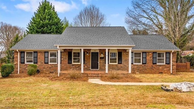 view of front of house featuring covered porch, brick siding, and a front lawn