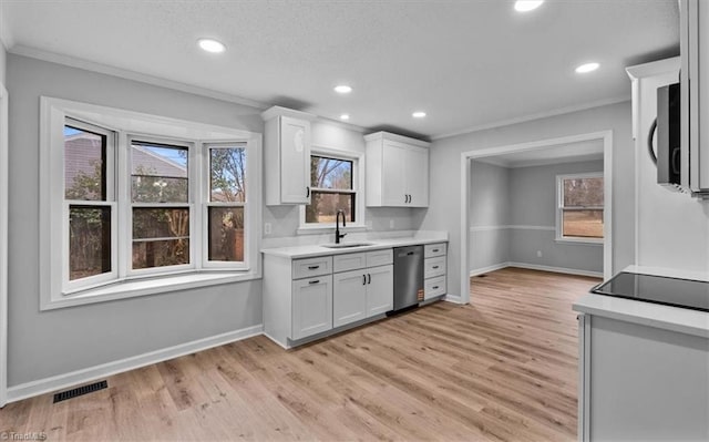 kitchen with crown molding, light countertops, visible vents, stainless steel dishwasher, and a sink