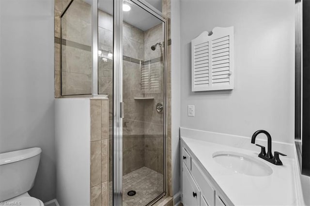 full bathroom with vanity, a shower stall, and toilet