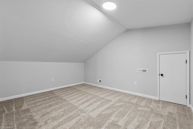 additional living space with carpet, visible vents, lofted ceiling, and baseboards