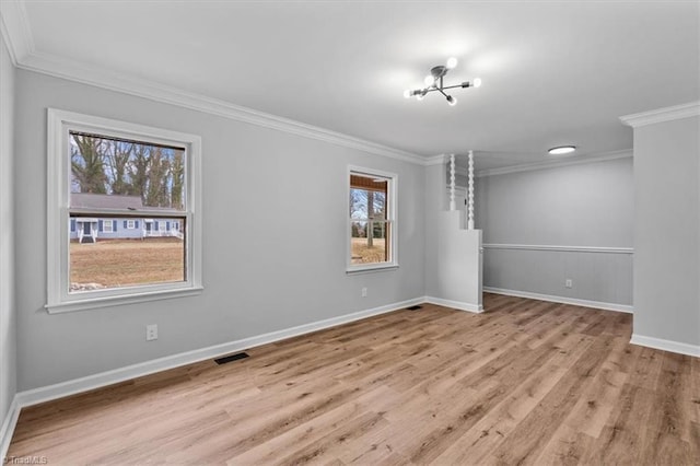 unfurnished room featuring baseboards, wood finished floors, visible vents, and crown molding