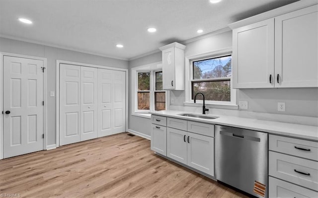 kitchen featuring a sink, ornamental molding, light countertops, and dishwasher