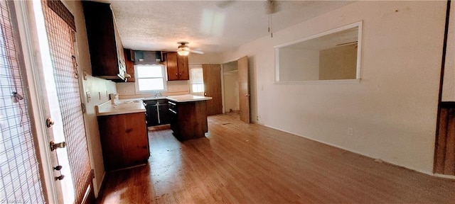305 Corliss St, Greensboro, NC 27406 - kitchen featuring light wood-style flooring, ceiling fan, light countertops, a kitchen island, and a sink