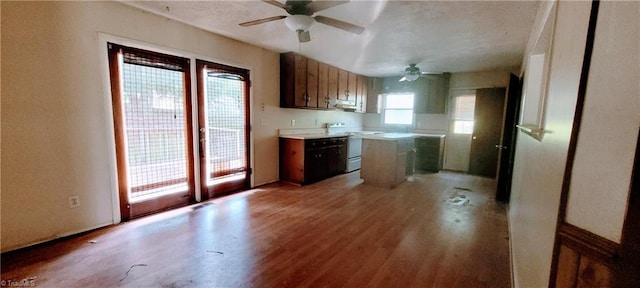 305 Corliss St, Greensboro, NC 27406 - kitchen with white electric range oven, a ceiling fan, light wood-type flooring, a kitchen island, and light countertops