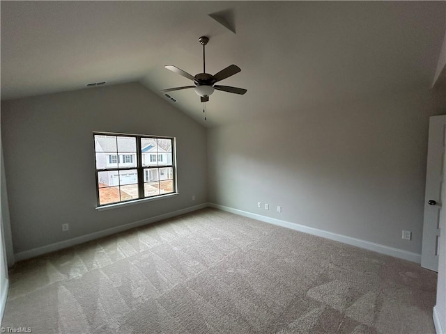 empty room featuring vaulted ceiling, light colored carpet, and ceiling fan