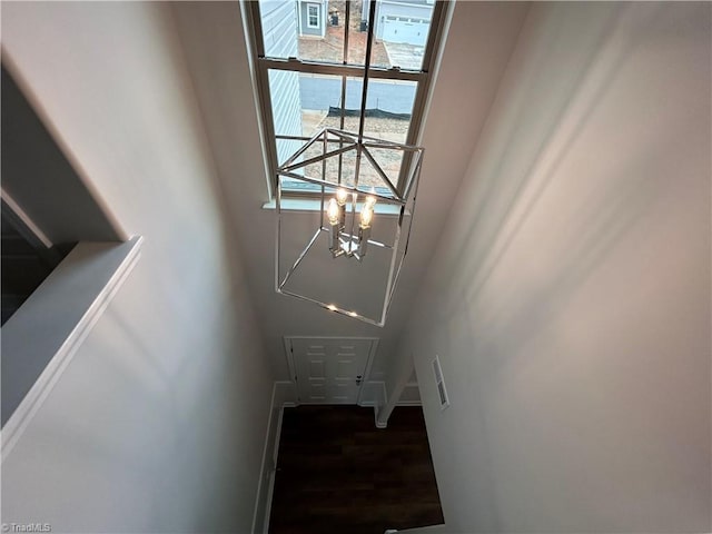 stairs featuring a chandelier, hardwood / wood-style floors, and a wealth of natural light