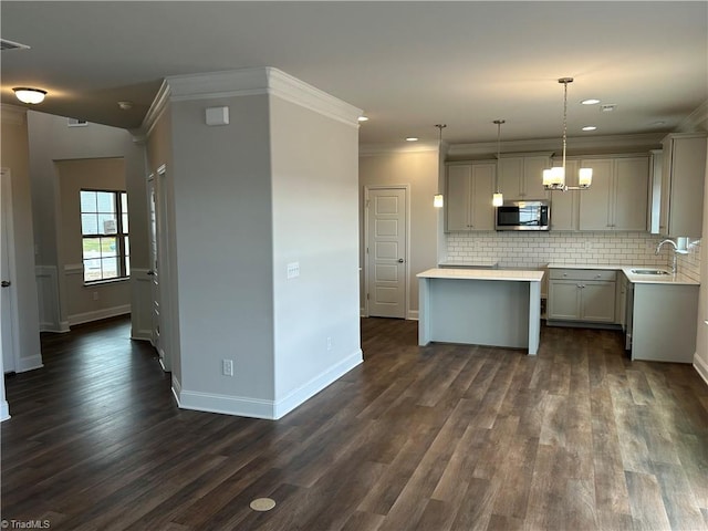 kitchen with pendant lighting, sink, tasteful backsplash, and gray cabinetry