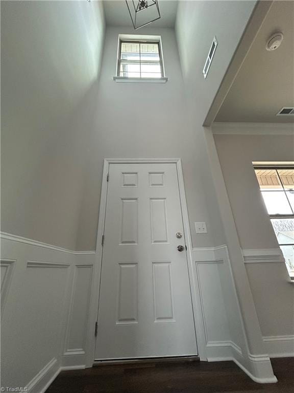 entrance foyer with dark hardwood / wood-style flooring and ornamental molding