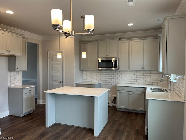 kitchen with crown molding, sink, gray cabinetry, and decorative light fixtures