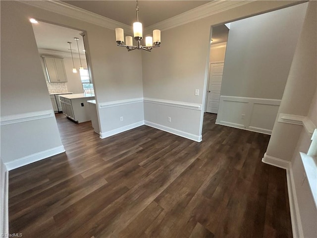 unfurnished dining area featuring crown molding, dark hardwood / wood-style flooring, and an inviting chandelier