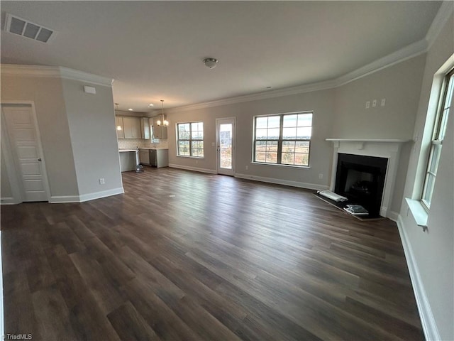 unfurnished living room featuring crown molding, dark hardwood / wood-style flooring, and a notable chandelier