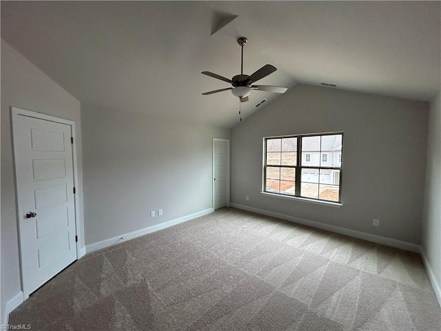 spare room with vaulted ceiling, light carpet, and ceiling fan