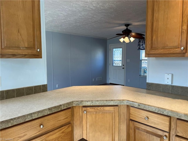 kitchen featuring ceiling fan and a textured ceiling