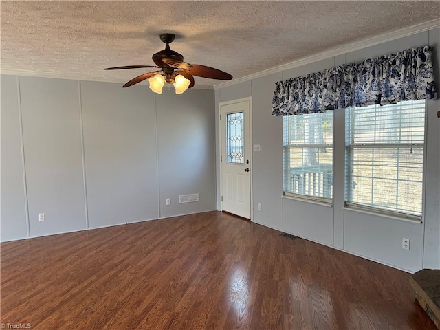 spare room with ornamental molding, dark hardwood / wood-style floors, ceiling fan, and a textured ceiling