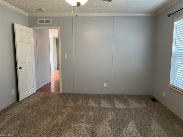 spare room with ornamental molding, a textured ceiling, and carpet