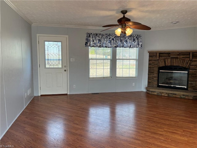 unfurnished living room with crown molding, a healthy amount of sunlight, a textured ceiling, and dark hardwood / wood-style flooring