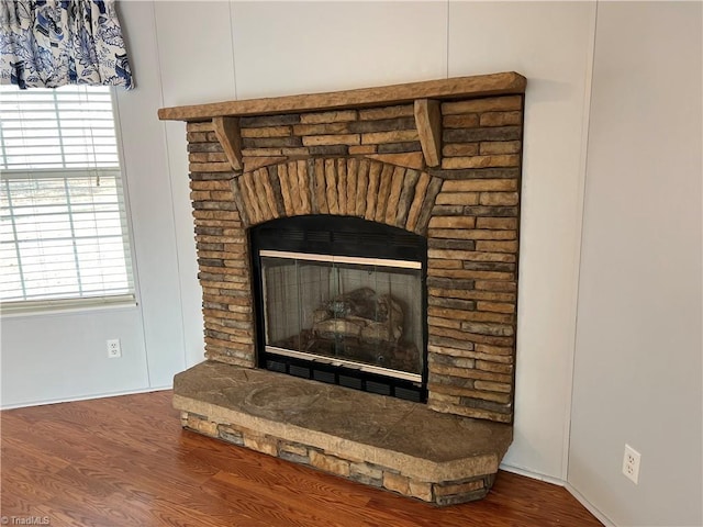 details with a stone fireplace and hardwood / wood-style floors