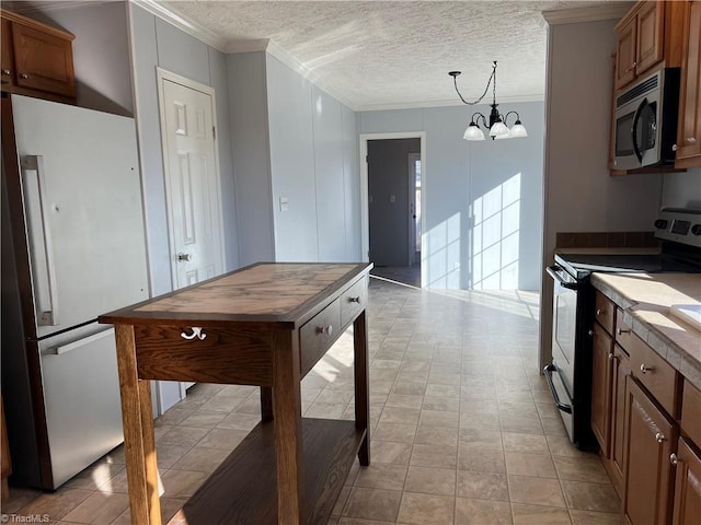 kitchen featuring a chandelier, hanging light fixtures, stainless steel appliances, crown molding, and a textured ceiling