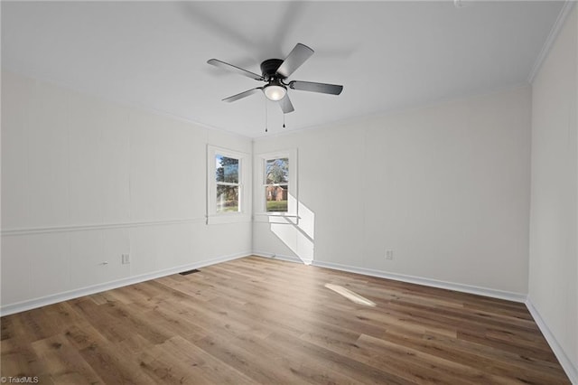 unfurnished room featuring visible vents, crown molding, a ceiling fan, and wood finished floors