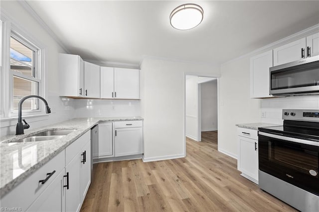 kitchen featuring a sink, light wood-style floors, appliances with stainless steel finishes, and crown molding