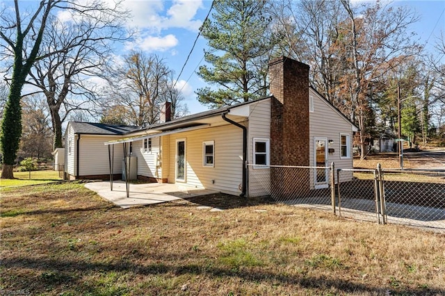 rear view of house with a patio area, fence, a lawn, and a chimney