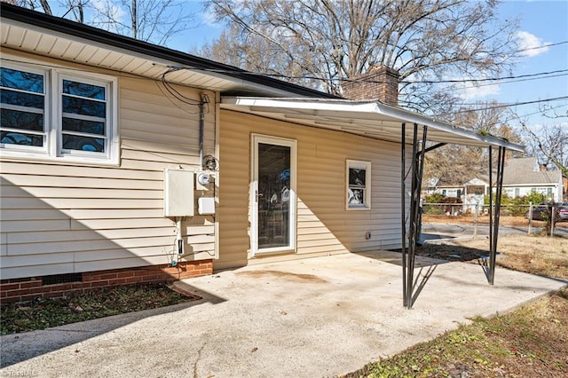 entrance to property featuring a patio area, fence, crawl space, and a chimney