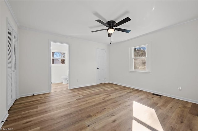 unfurnished bedroom featuring crown molding, light wood-style flooring, and multiple windows